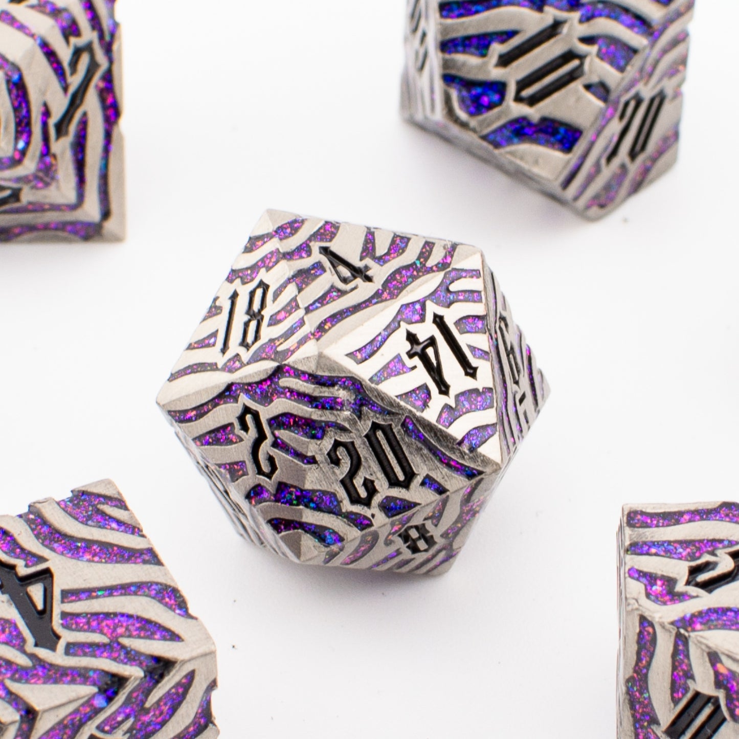 Close‑up of the Nebula Covenant solid metal D20 showing purple‑sparkle inlays, engraved detailing, and metallic silver finish.