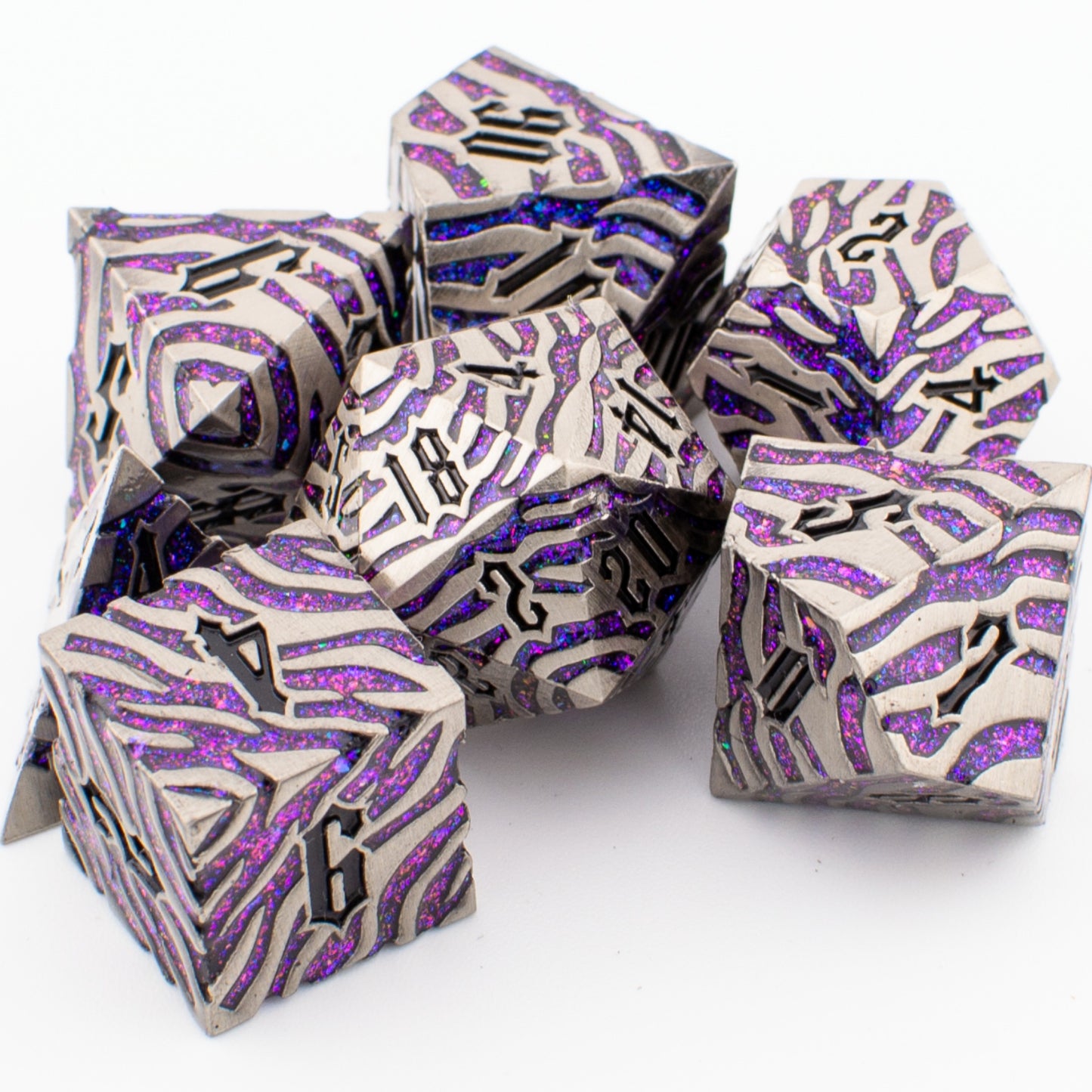 Nebula Covenant solid metal purple‑sparkle RPG dice set arranged loosely on a white surface, showing engraved polyhedral designs with shimmering purple inlays.