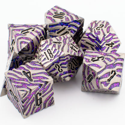 Nebula Covenant solid metal purple‑sparkle RPG dice set arranged loosely on a white surface, showing engraved polyhedral designs with shimmering purple inlays.