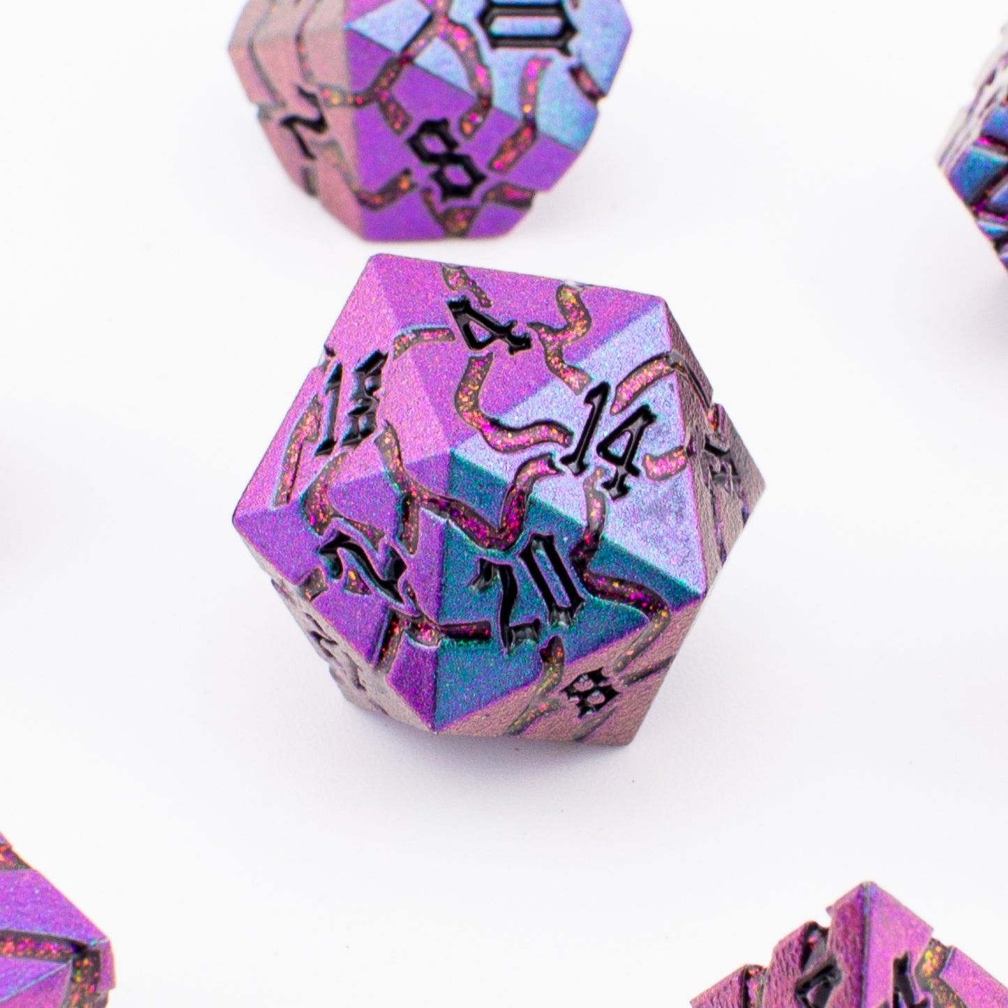Close‑up view of the Void Weaver metal RPG dice showing purple and blue enamel inlays and detailed engraved patterns.