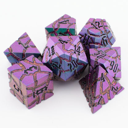 Void Weaver metal polyhedral dice set displayed loosely on a white surface, highlighting the enamel colours and intricate engraved detailing.