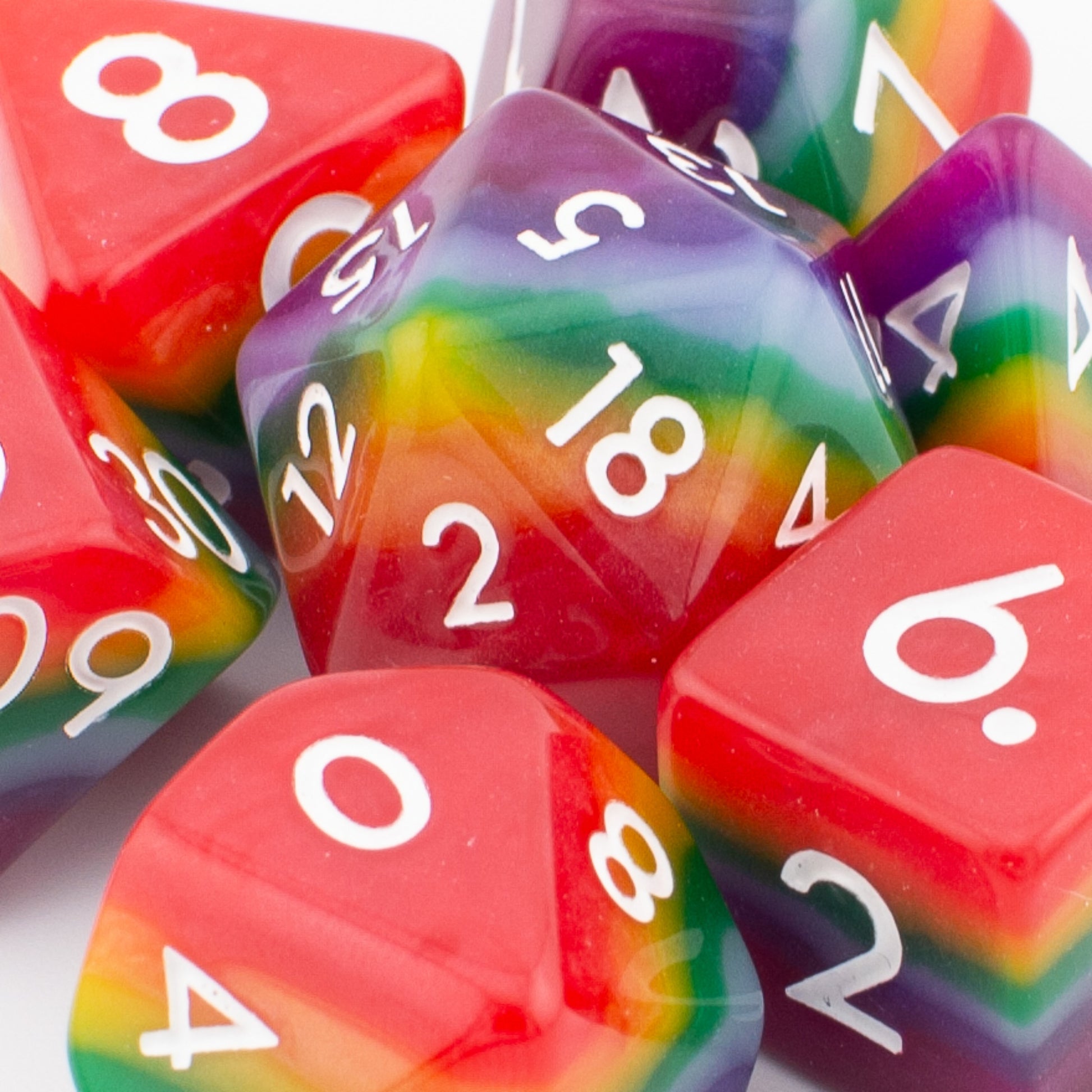 Close‑up of Rainbow Pride soft‑edge acrylic RPG dice showing smooth edges, bright rainbow colouring, and crisp engraved numbers.