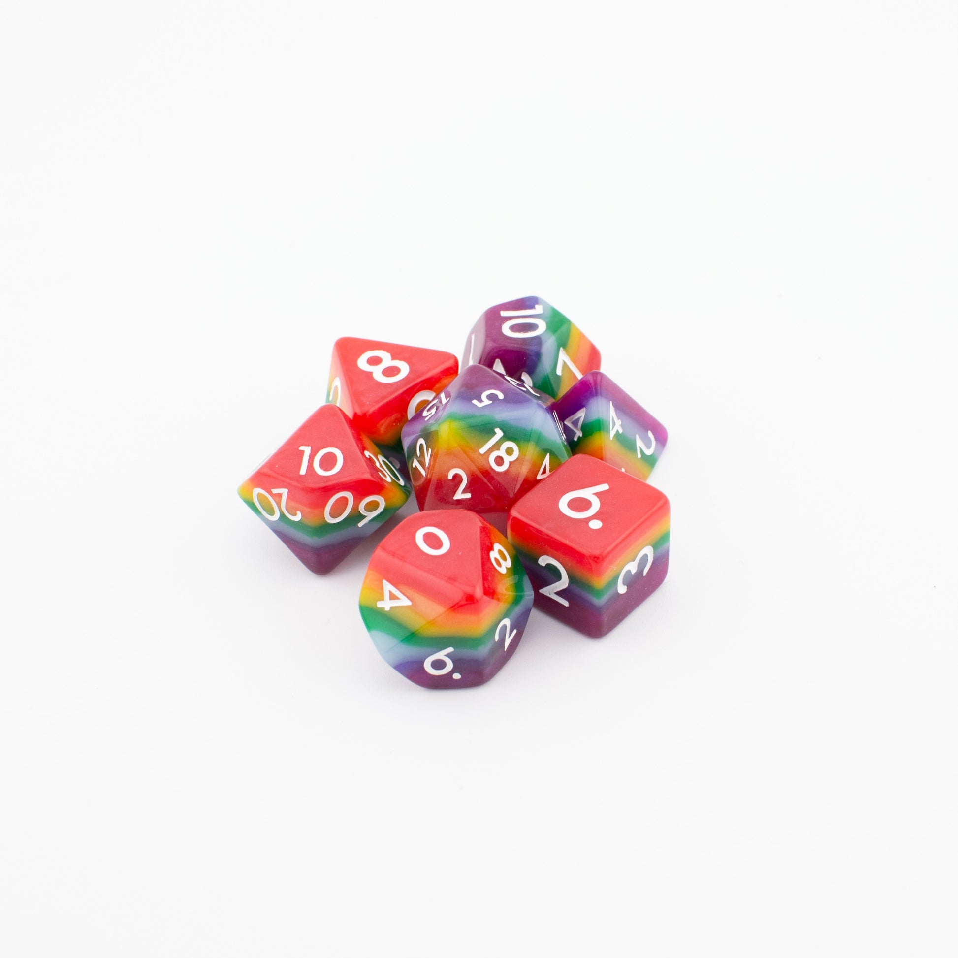 Rainbow Pride soft‑edge acrylic dice set arranged loosely on a white background, displaying all seven vibrant rainbow polyhedral dice.