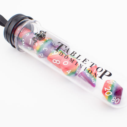 Rainbow Pride soft‑edge acrylic RPG dice set packaged in a clear display tube, showing all seven colourful polyhedral dice.