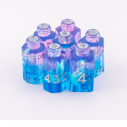Tabletop Dominion Prismatic Elixir potion bottle dice arranged together showing blue‑to‑purple iridescent resin with silver numbering.