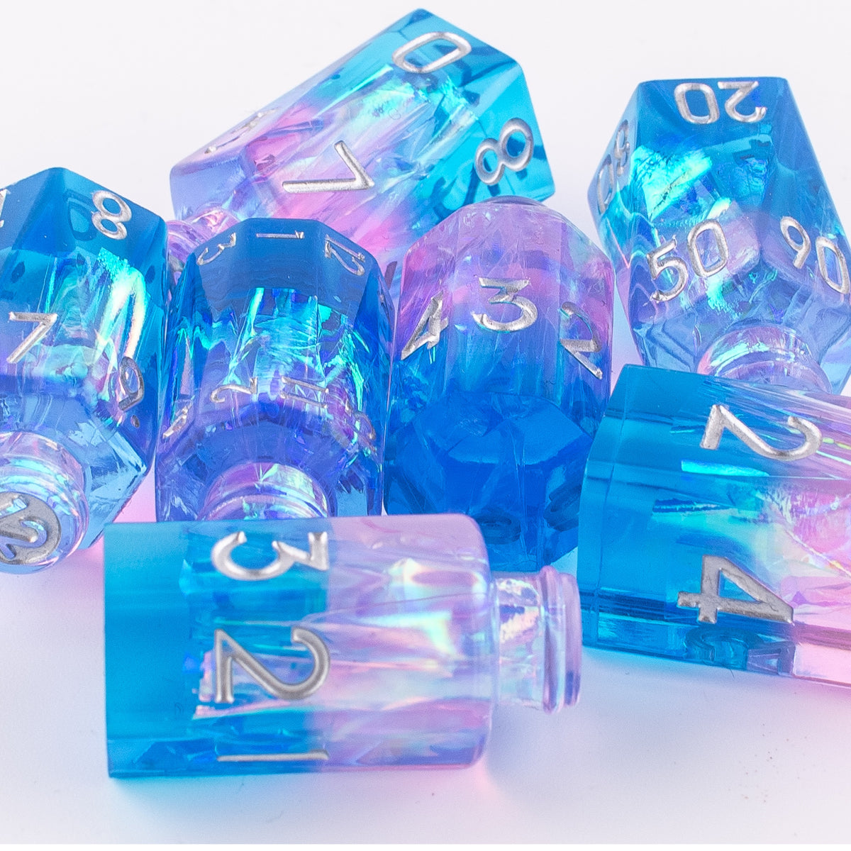 Tabletop Dominion Prismatic Elixir potion bottle dice arranged together showing iridescent blue‑purple‑pink resin with metallic numbering.