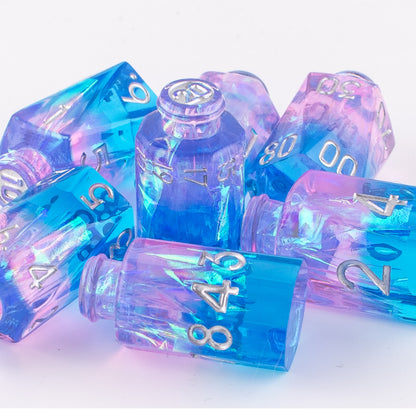 Tabletop Dominion Prismatic Elixir potion bottle dice piled together on a white background with blue‑pink iridescent resin and silver numbering.