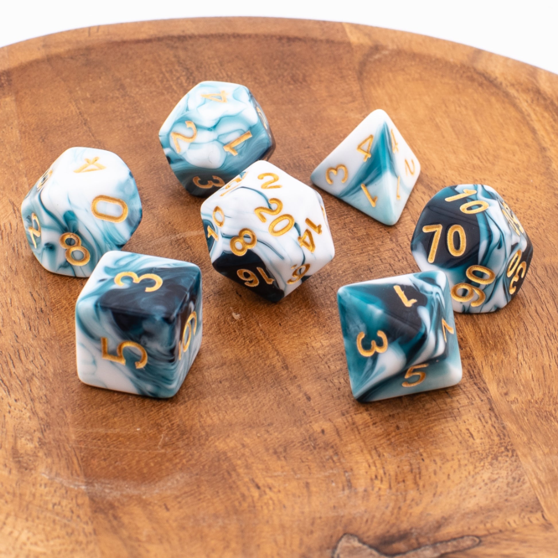 Whispering Depths acrylic dice scattered across a wooden tabletop.