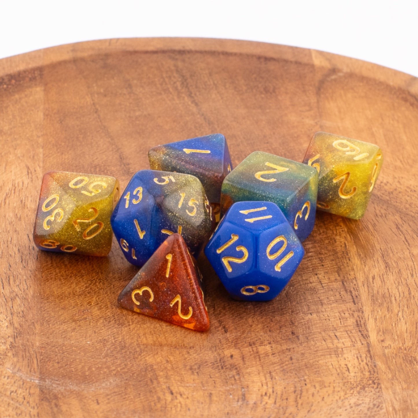 Starlight Cascade acrylic dice neatly arranged on a wooden surface.