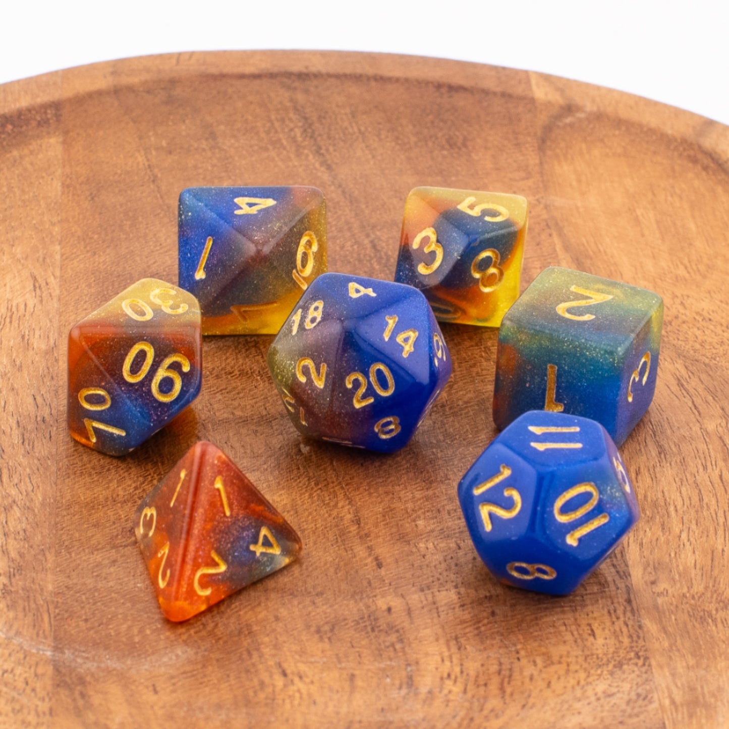 Starlight Cascade acrylic dice scattered across a wooden tabletop.