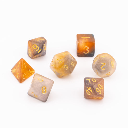 Clear Autumn soft‑edge acrylic dice arranged neatly on a white background, showing all seven translucent orange‑and‑grey dice with gold numbering.