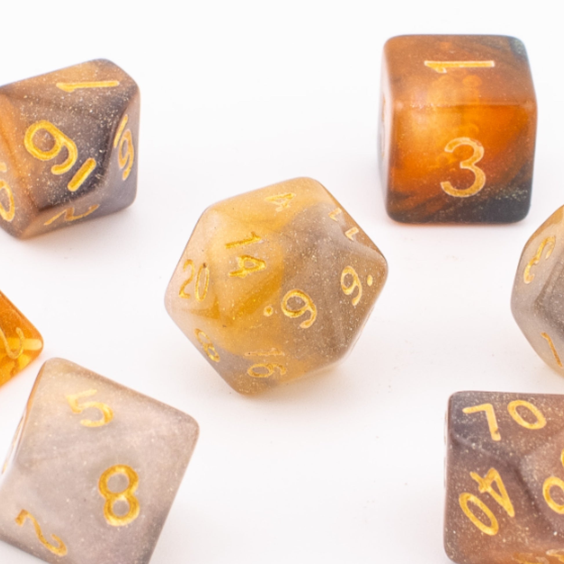 Clear Autumn acrylic dice clustered together on a white background, highlighting the mixed orange and grey translucency and gold‑inked faces.