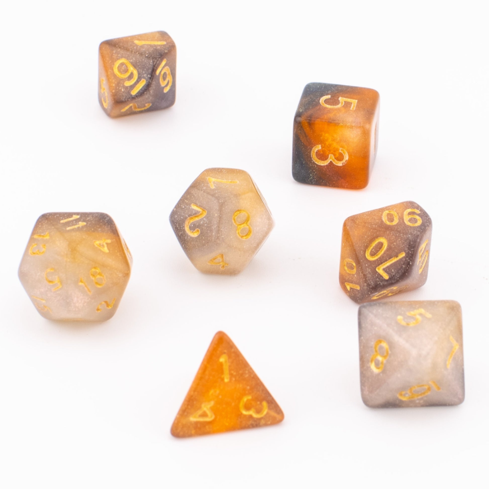 Clear Autumn acrylic dice scattered loosely across a white background, showing varied angles of the translucent orange‑grey colour blend.