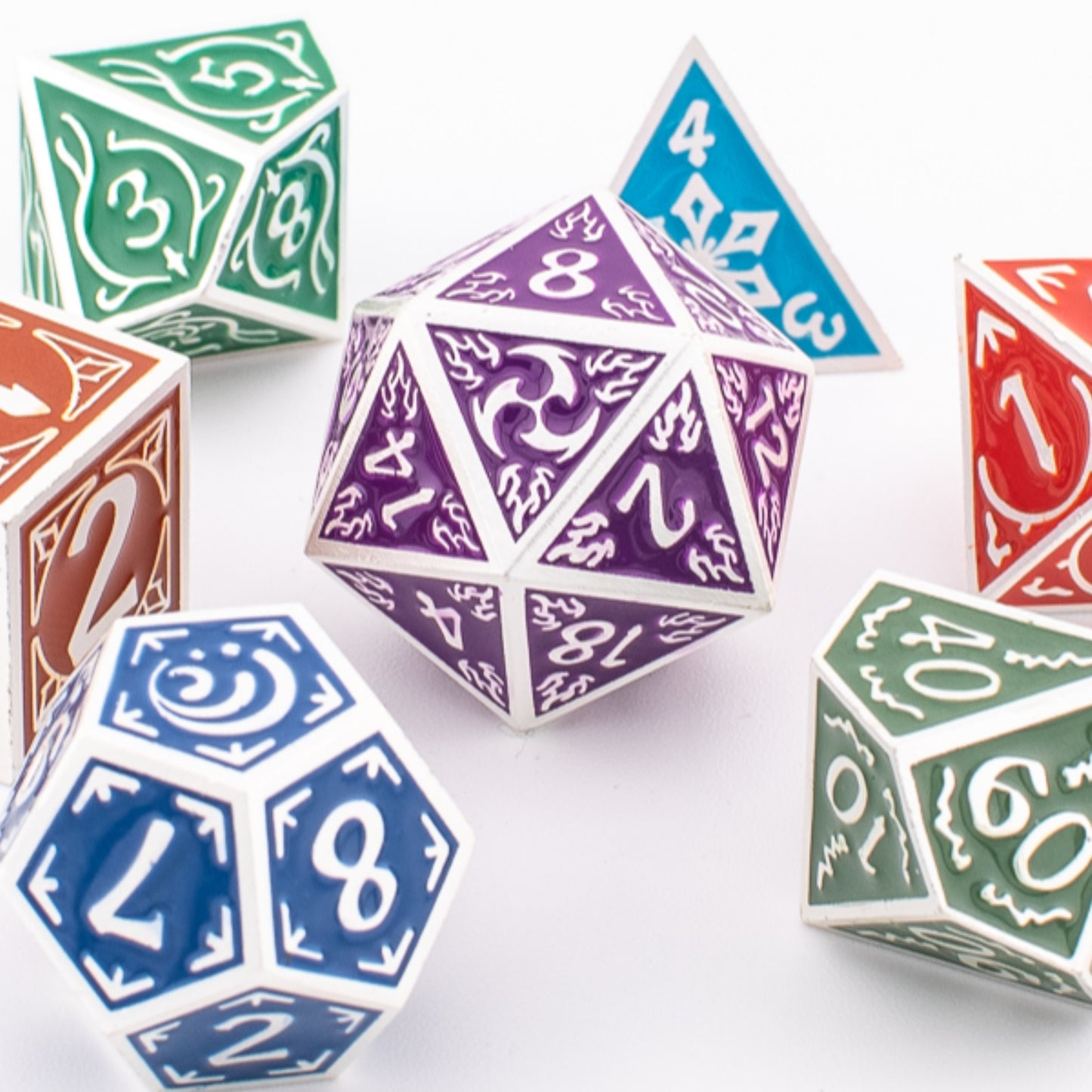Tabletop Dominion Prismatic Elemental metal dice spread out, showing multicoloured engraved designs across all seven polyhedral shapes.