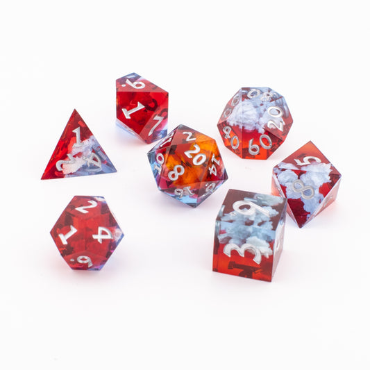 Ember Cloud sharp‑edge resin dice arranged on a white background, showing all seven dice with red‑and‑blue cloud inclusions and white numbering.