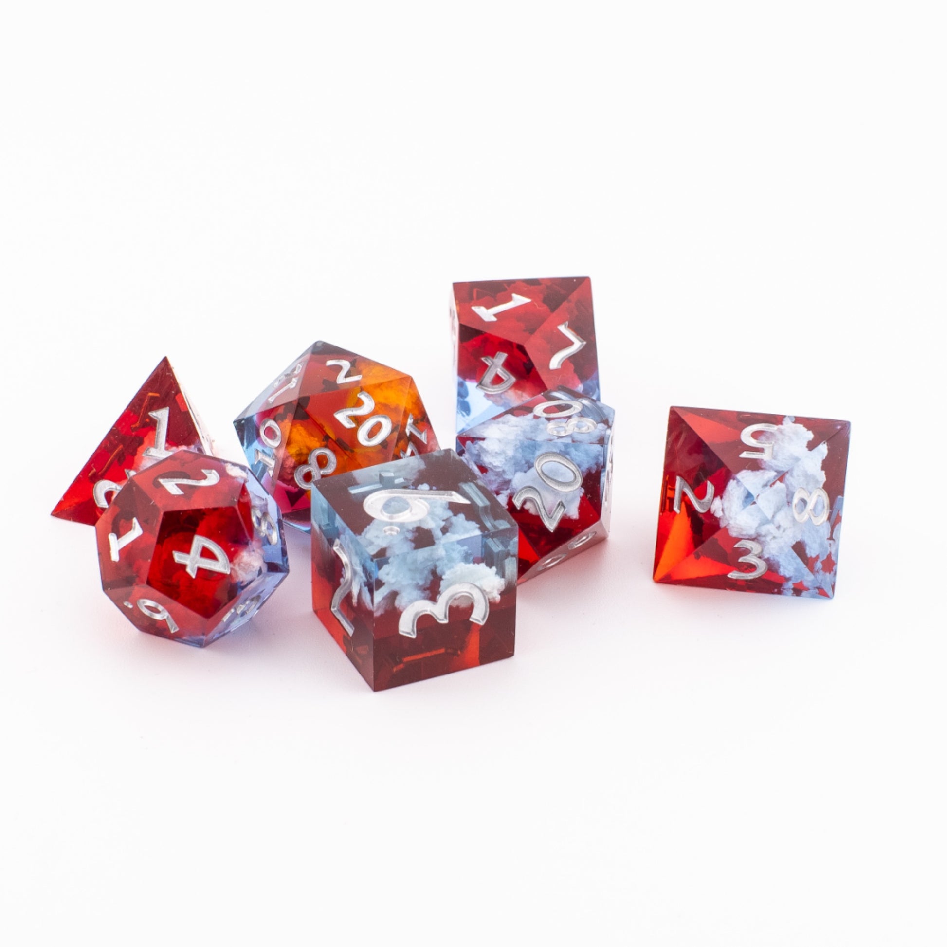 Ember Cloud sharp‑edge dice scattered loosely across a white background, showing varied angles of the red‑orange sunset tones and cloud‑like inclusions.