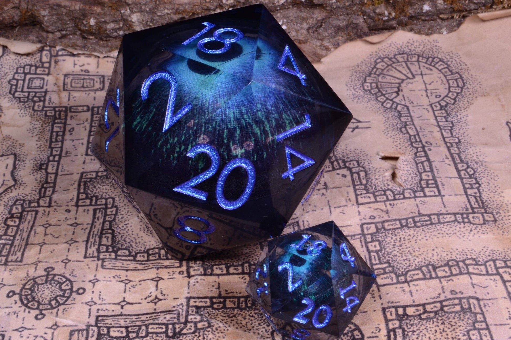 Front facing view of the evil eye large d20 sat next to the d20 in the 7-piece dice set